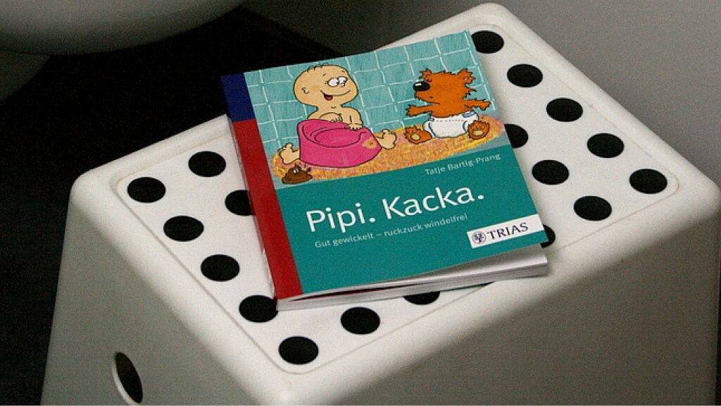 Das Buch Pipi.Kacka. auf einem Tritthocker vor der Toilette