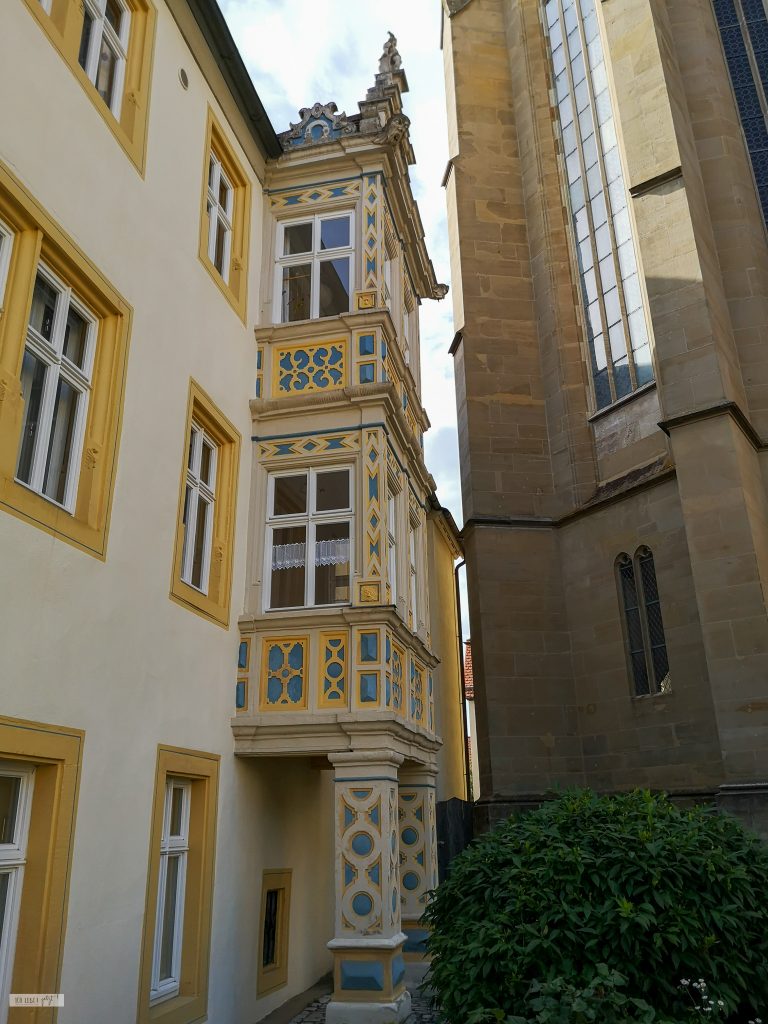 Haus in Rothenburg o.T. mit gelb gerahmten fenstern und reichlich verziertem Anbau